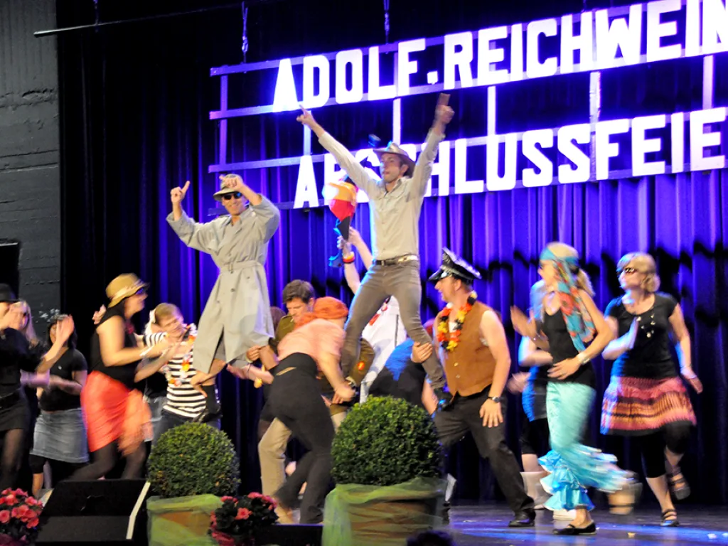 Tanzgruppe in Kostümen auf der Bühne.